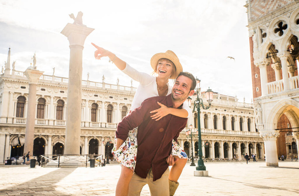 Beatiful young couple having fun while visiting Venice - Tourists travelling in Italy and sightseeing the most relevant landmarks of Venezia - Concepts about lifestyle, travel, tourism - Valokuva, kuva