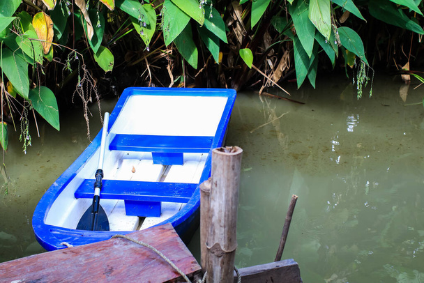 Станція стикування з блакитним пластиковим човном на водяній поверхні досі, а вода для відпочинку готова для людей, які готові до веслування
 - Фото, зображення