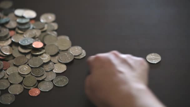 de handen van een man die gestapelde munten sorteert. - Video