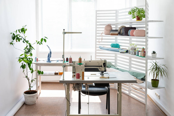 there is sewing equipment in a spacious bright room - Photo, Image