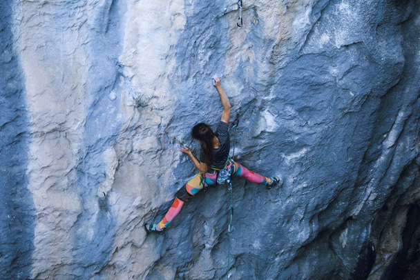 Silna dziewczyna wspina się na skałę, Wspinaczka skalna w Turcji, Trening wytrzymałościowy i siłowy, Kobieta w sporcie ekstremalnym, Wspinaczka skalna trenuje w przyrodzie. - Zdjęcie, obraz