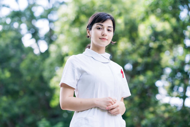 Outdoor portrait of young woman posing in white coat on fine day - Photo, Image