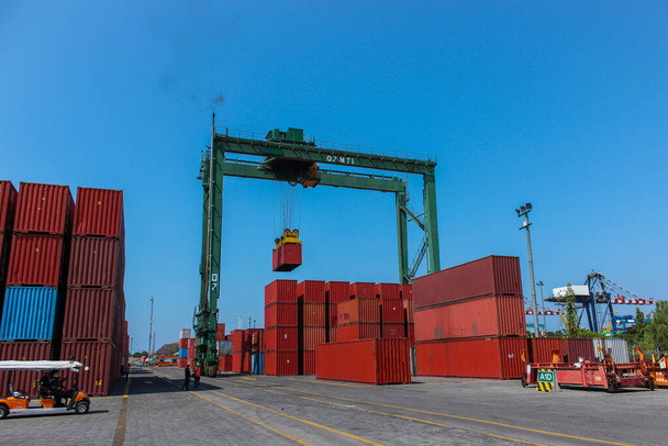 Grúa industrial moviendo los contenedores de envío, actividades en la importación de exportación y puerto comercial en Yakarta, Indonesia
 - Foto, Imagen
