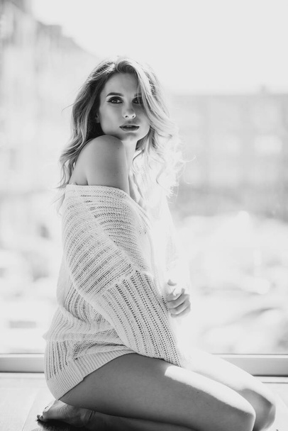Beautiful sexy pregnant woman in a white transparent blouse on the background of a window in the backlight. Black and white photo. Fine art. Expectation of a child. Soft selective focus. - Photo, Image