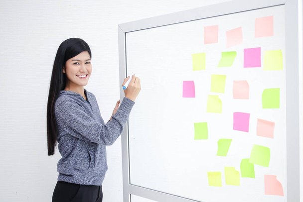 Asian girl tutor Write job information on the whiteboard. Educational concepts, online teachers - Photo, Image