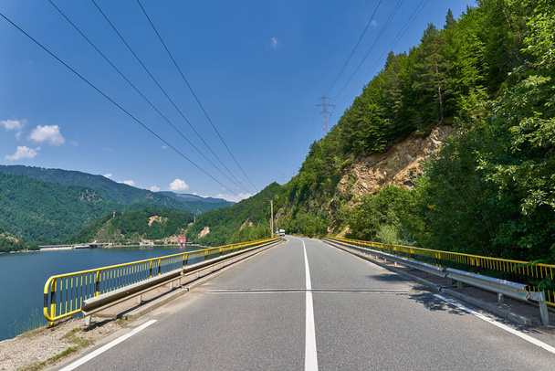 Road by a dam lake in the mountains - Fotoğraf, Görsel