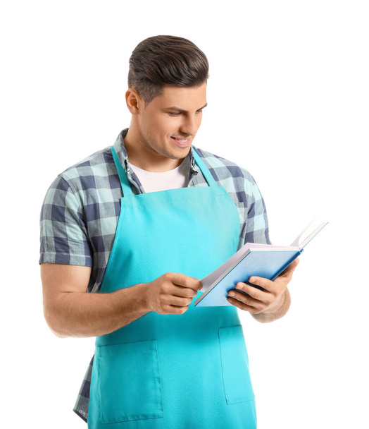 Young man with recipe book on white background - Fotoğraf, Görsel