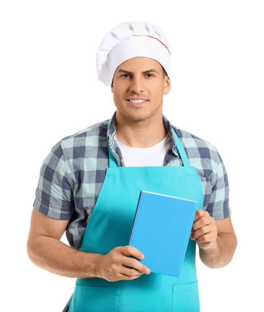 Young man with recipe book on white background - Photo, Image