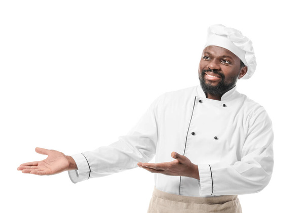 man Afro-Amerikaanse chef tonen iets op witte achtergrond - Foto, afbeelding