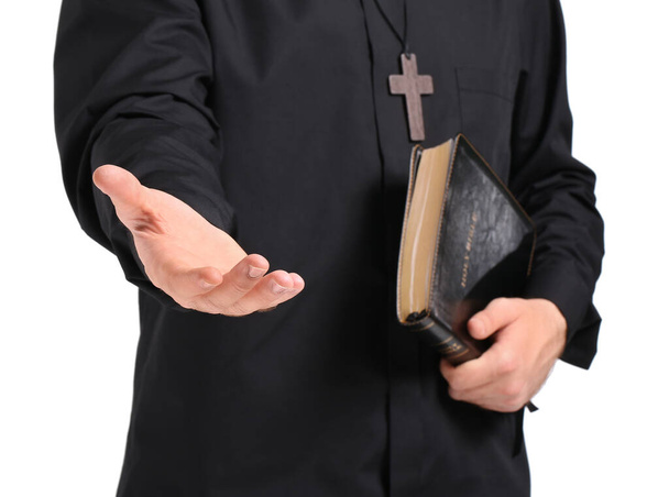 Handsome young priest with Bible on white background, closeup - Photo, Image