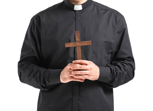 Joven sacerdote con cruz sobre fondo blanco
 - Foto, imagen