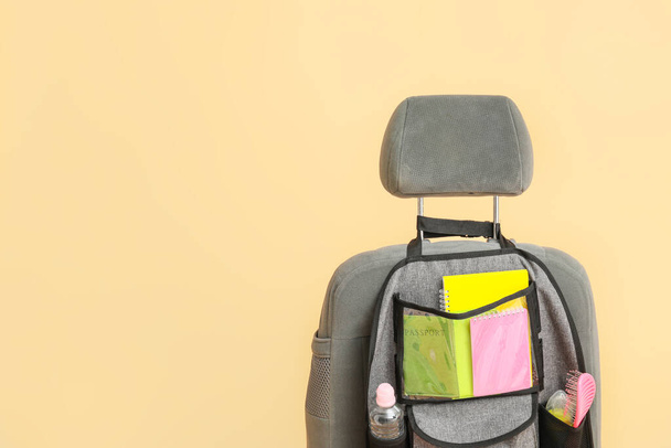 Travel organizer with different things on car seat against color background - Photo, Image