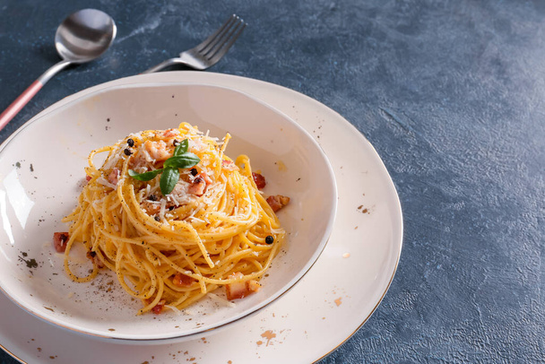 Plate with tasty pasta carbonara on dark background - Photo, image