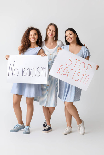 Mujeres de diferentes nacionalidades con pancartas sobre fondo blanco. Detener el racismo
 - Foto, imagen