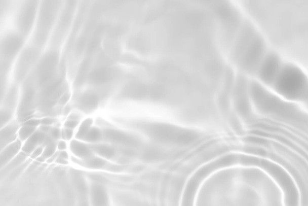 Close-up van gedeatureerde transparante heldere, kalme wateroppervlaktextuur met spatten en bellen. Trendy abstracte natuur achtergrond. Wit-grijze watergolven in zonlicht. - Foto, afbeelding