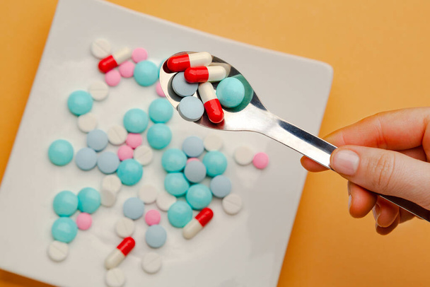 Pillole colorate in cucchiaio, preparate per mangiare. Concetto di tossicodipendenza, integratore alimentare contro frutta e verdura fresca. Foto di alta qualità - Foto, immagini