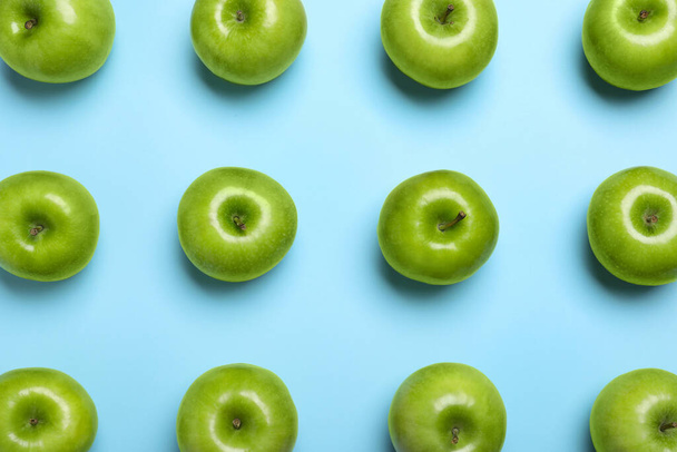 Tasty green apples on light blue background, flat lay - Фото, изображение