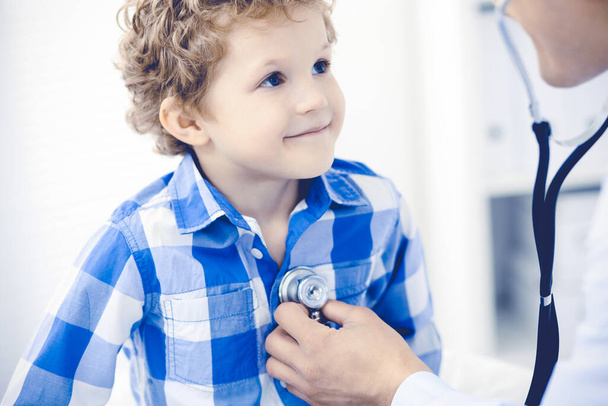 Doctor and patient child. Physician examining little boy. Regular medical visit in clinic. Medicine and health care concept - Photo, image