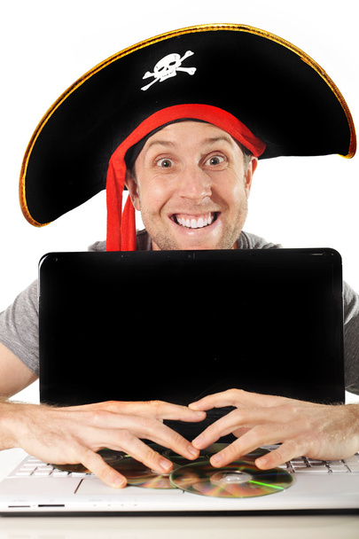 Νεαρός άνδρας στο κοστούμι πειρατών και υπολογιστή - Φωτογραφία, εικόνα