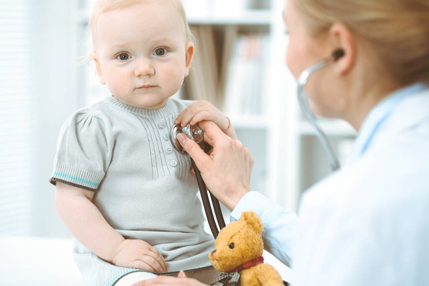 Doctor and patient in hospital. Little girl is being examined by doctor with stethoscope. Medicine concept - Foto, imagen