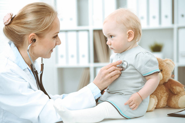 Doctor and patient in hospital. Little girl is being examined by doctor with stethoscope. Medicine concept - Photo, Image