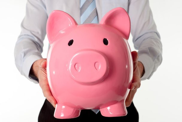 pink piggy bank with businessman in the background - 写真・画像