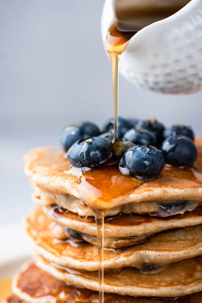 Maple syrup pouring on stack of pancakes - Photo, image