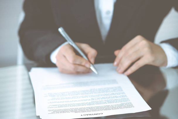 Unknown female hands with pen over document of contract. Agreement signing or business concept - Photo, Image