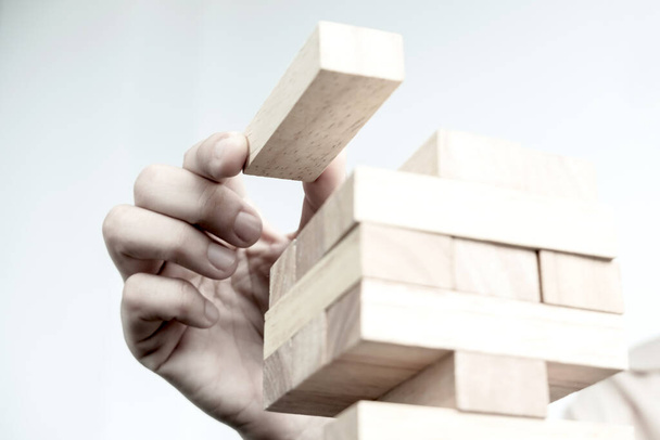 木製のブロックゲームをプレイビジネス女性の手。事業成長と成功のための経営計画と戦略計画のリスク. - 写真・画像