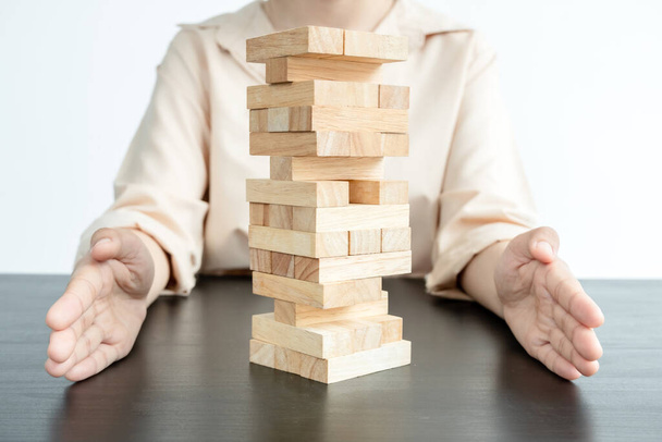 Hands of businesswoman prevent wooden blocks, gambling placing wooden blocks. Concept risk of management and strategy plans for business growth and success. - Φωτογραφία, εικόνα