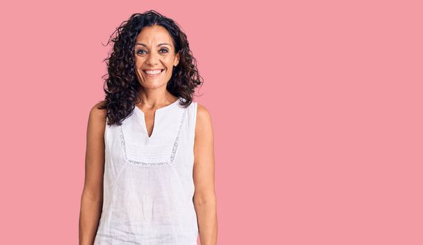 Middle age beautiful woman wearing casual sleeveless t shirt looking positive and happy standing and smiling with a confident smile showing teeth  - Photo, Image