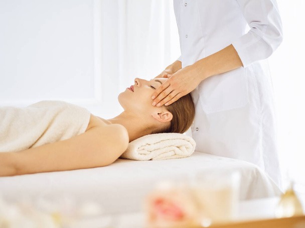 Mulher bonita desfrutando de massagem facial com olhos fechados - Foto, Imagem
