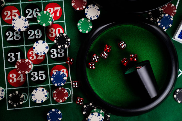 Roulette table in casino. Casino felt green table with red and black numbers. Stack of poker chips. - Foto, afbeelding
