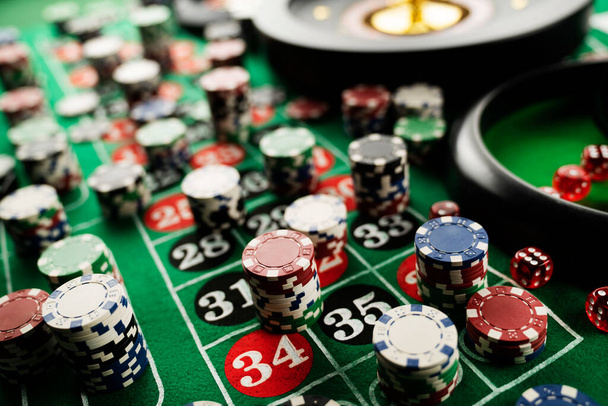 Roulette table in casino. Casino felt green table with red and black numbers. Stack of poker chips. - Photo, Image