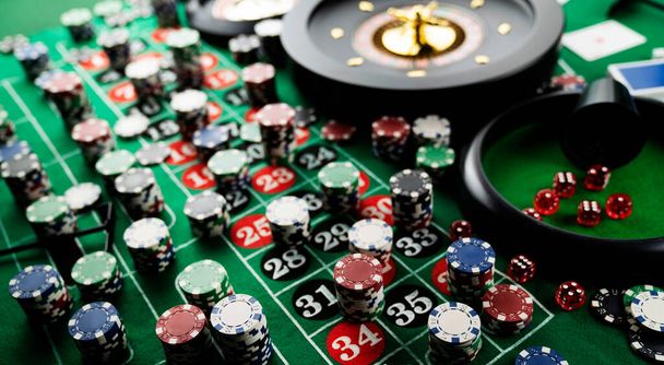 カジノのルーレットテーブル。カジノは赤と黒の数字で緑のテーブルを感じた。ポーカーチップのスタック. - 写真・画像