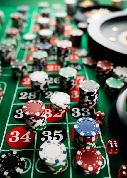 Mesa de ruleta en el casino. Casino se sentía mesa verde con números rojos y negros. Pila de fichas de póquer
. - Foto, imagen