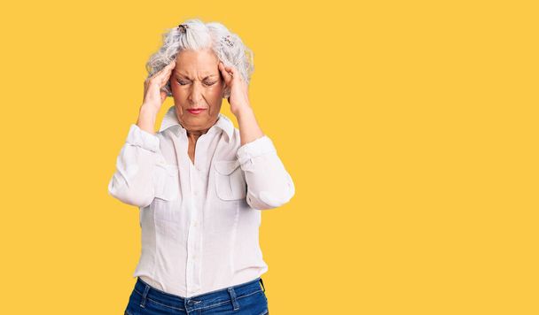 Senior grey-haired woman wearing casual clothes with hand on head for pain in head because stress. suffering migraine.  - Foto, afbeelding