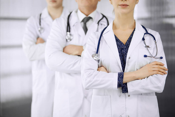 Doctors standing as a team with arms crossed in clinic. Medical help, insurance and medicine concept - Fotoğraf, Görsel