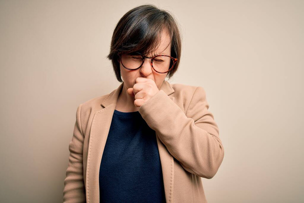 Young down syndrom obchodní žena nosí brýle stojí nad izolovaným pozadím pocit nevolnosti a kašle jako symptom pro nachlazení nebo zánět průdušek. Koncept zdravotní péče. - Fotografie, Obrázek