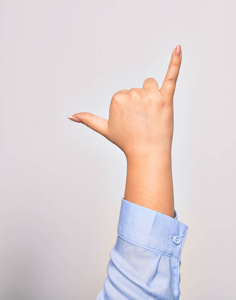 Hand of caucasian young woman doing surf salutation. Showing fingers doing telephone sign over isolated white background - Photo, Image