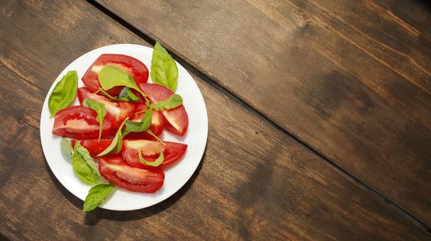 Tomates en rodajas con lechuga en un plato blanco. Concepto de alimentación saludable. Foto de alta calidad
 - Foto, imagen