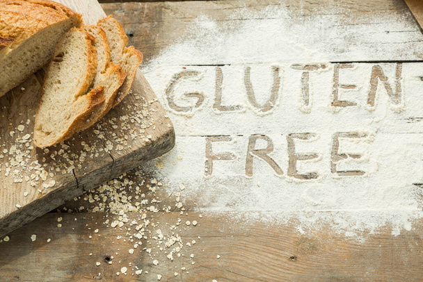 Palabra sin gluten escrita en una harina con pan casero. Concepto de dieta especial para personas con alergia. Foto de alta calidad
 - Foto, imagen