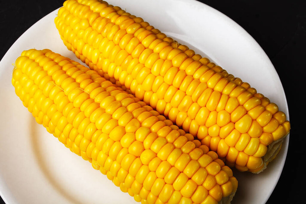 gekochter Mais auf einem weißen Teller, Nahaufnahme, selektiver Fokus - Foto, Bild