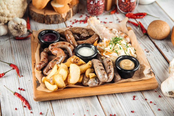 Large sausage platter sauerkraut potatoe and sauce - Photo, Image