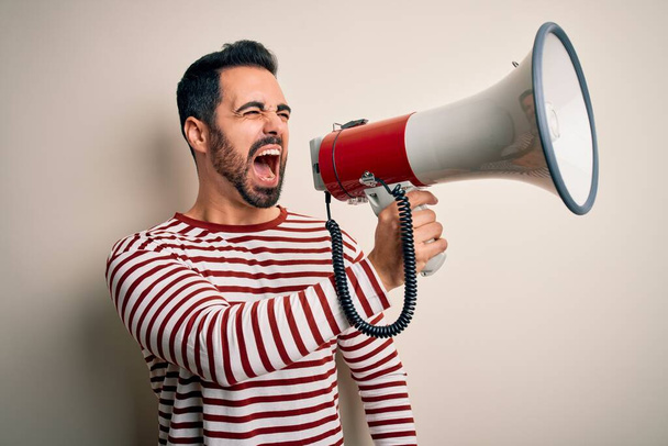 Un homme hispanique criant en colère contre une manifestation à travers un mégaphone. Hurlements excités sur ludspeaker parler et crier nouvelles - Photo, image