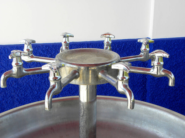   Eight water taps are arranged in a circle. Old water street tap, closed tap.                                 - Photo, Image