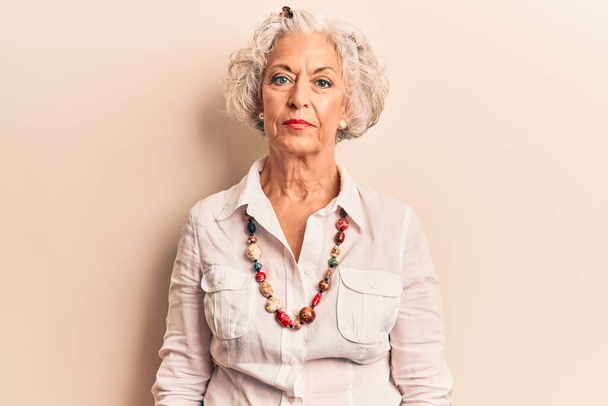 Senior grey-haired woman wearing casual clothes with serious expression on face. simple and natural looking at the camera.  - Photo, Image