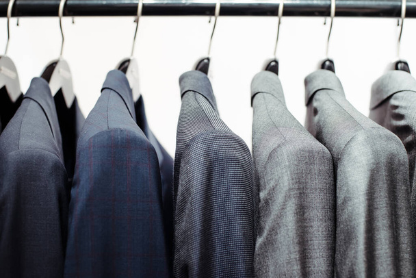 Men's clothing store. Men's business jackets on hangers in a shop window - Photo, Image