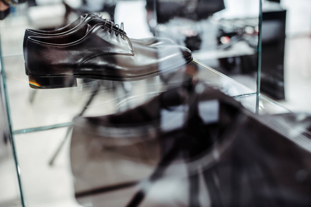 Sklep z odzieżą męską. Męskie czarne skórzane buty derby na półce sklepowej - Zdjęcie, obraz