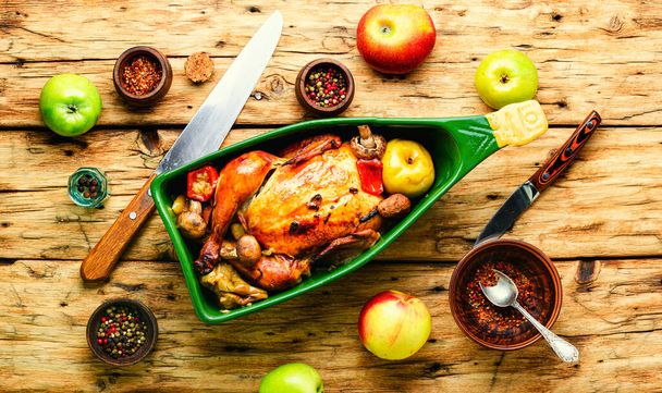 Pollo al horno con manzanas en la vieja mesa de madera.Pollo frito con manzanas.Pollo asado con manzanas en bandeja para hornear
 - Foto, imagen